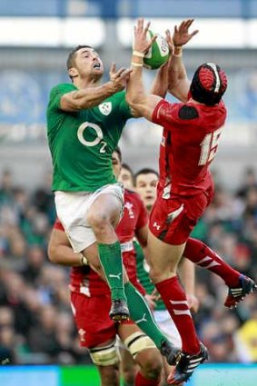 Big men fly: Ireland's Rob Kearney and Wales' Leigh Halfpenny clash for the ball during their Six Nations match.