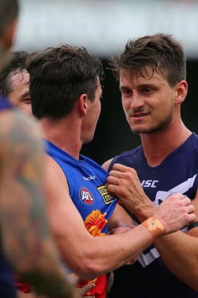 Tom Rockliff of the Lions and Alex Silvagni of the Dockers exchange words.