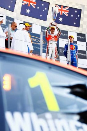 Jamie Whincup lifts the trophy after winning in Abu Dhabi.