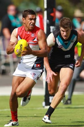 Neville Jetta of the Demons gets away from Paul Stewart of the Power.