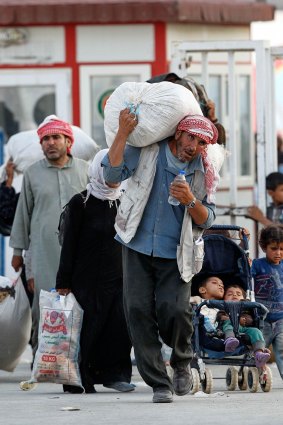 Syrian refugees walk to cross into Turkey at Akcakale on Monday.