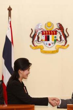 An uneasy alliiance ... Prime Minister Yingluck Shinawatra and her Malaysian counterpart Najib Razak shake hands.