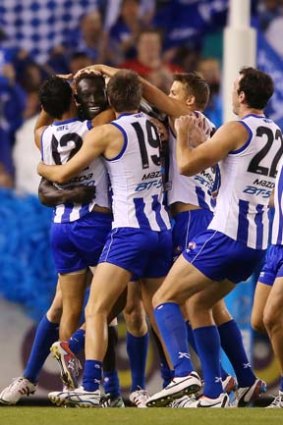 He's arrived: Majak Daw is congratulated on his first goal by his North Melbourne teammates.