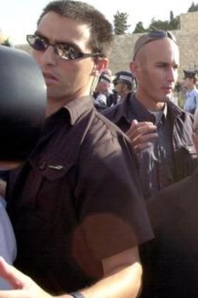 Comeback: Israeli security men and police surround Sharon during his controversial visit to the precincts of the al-Aqsa mosque in occupied East Jerusalem in September 2000. Within months he would be prime minister.   