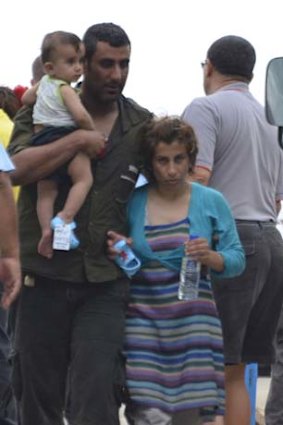 On the move: A refugee family offloaded at Christmas Island on Tuesday.