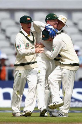 Mobbed: Australian players surrounf Brad Haddin after the wicketkeeper took a spectacular catch down the legside to dismiss  Alastair Cook.