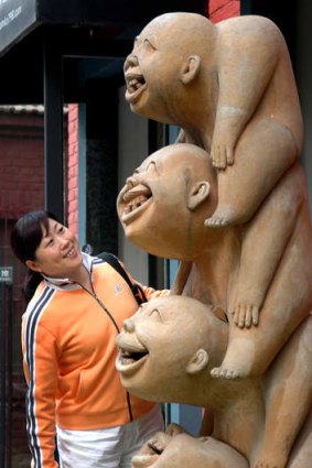 A tourist shares smiles with a sculpture.
