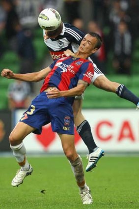 Leigh Broxham of Melbourne Victory is challenged by Ryan Griffiths of the Newcastle Jets during the round 22 A-League match at AAMI Park.