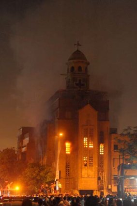 Firefighters extinguish a fire on a church after clashes between Muslims and Christians in Cairo.