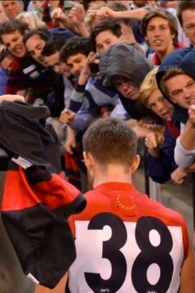 Fans vent their anger as Melbourne players walk back after losing to Essendon.