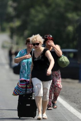Fleeing residents of Shakhtersk carry their belongings in bags as they run to waiting cars on the outskirts of the town during heavy shelling. 
