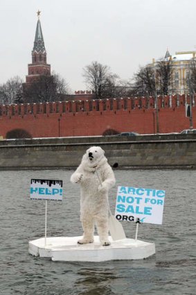 Wearing a polar bear costume a Greenpeace activist takes floats on the Moskva River in front of the Kremlin in Moscow.