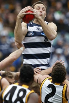 Geelong star Brad Ottens marks strongly over a pack of Hawks players.