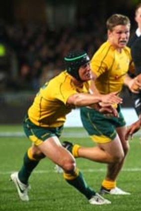 Hanging on: All Black Israel Dagg makes a break through the Wallabies line at Eden Park yesterday.