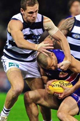 Who's ducking now? Bulldog's Tory Dickson tackled high by Geelong's Joel Selwood.