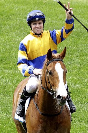 Jockey Tommy Berry waves to the crowd after riding Karuta Queen to victory.