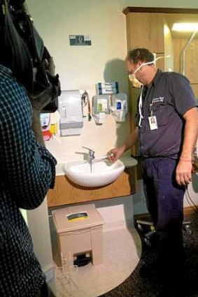 A hospital staffer tests the water temperature at the Wesley Hospital, Brisbane.