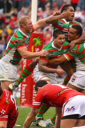 Celebration ... Souths players bring the Dragons to their knees.