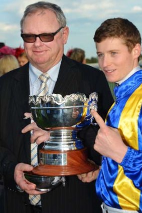 Trainer Murray Baker and jockey James McDonald pose with the trophy after It's A Dundeel won the Underwood Stakes.