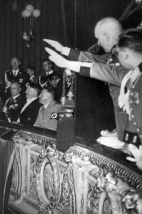 Adolf Hitler sitting between his close collaborator Martin Bormann, right, and future Governor of Austria Arthur Seyss Inquart, left, at Vienna's Opera in March 1938. Officers in the next box give Hitler the nazi salute.