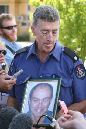 "David loved the fire brigade and the fire brigade family'' ... Canberra firefighter Ged Morrison holds a photo of his dead friend and colleague, David Balfour, yesterday.