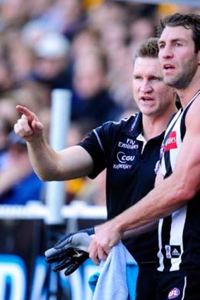 Collingwood coach Nathan Buckley gives Travis Cloke instructions during the game.