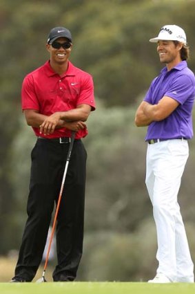 All smiles: Tiger Woods and Aaron Baddeley find something amusing yesterday.