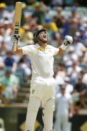 Shane Watson throws his arms up in celebration after reaching his century.