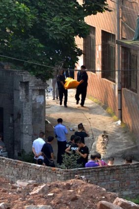 Bloody end ... Chinese police remove the body of Zhou Kehua, a fugitive armed robber and suspected serial killer, dubbed China's most dangerous man, after he was shot dead.