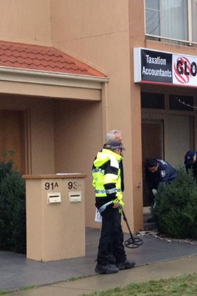Police officers search the area surrounding the Gungahlin tattoo parlous.