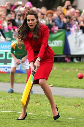 Kate demonstrates how to put bat on ball.