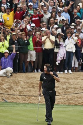On the 18th green, Phil Mickelson tips his visor to the crowd