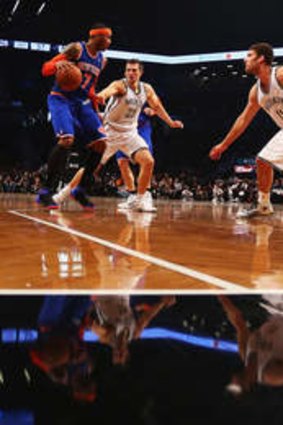 Carmelo Anthony of the New York Knicks dribbles against Mirza Teletovic of the Brooklyn Nets and Brook Lopez during their game at the Barclays Center.