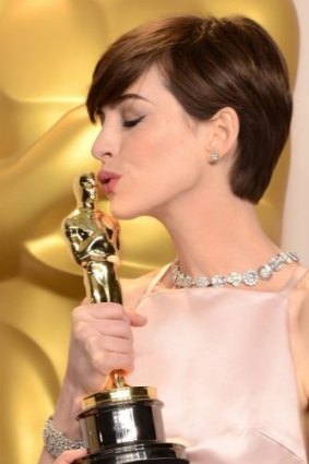 Anne Hathaway kisses her best supporting actress award for <i>Les Miserables</i> in 2013.