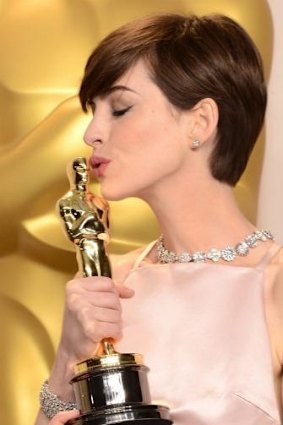 Anne Hathaway kisses her best supporting actress award for <i>Les Miserables</i> in 2013.