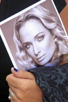 Memory never dies: a mourner holds a photo of Reeva Steenkamp at her funeral in February 2013.