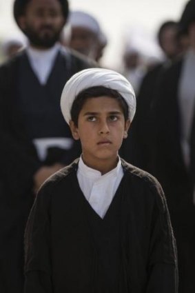 A 12-year-old Shiite religious student stands in front of Shiite clerics at a demonstration against the Islamic State of Iraq and the Levant (ISIL) in the Shiite holy city of Najaf in Iraq.
