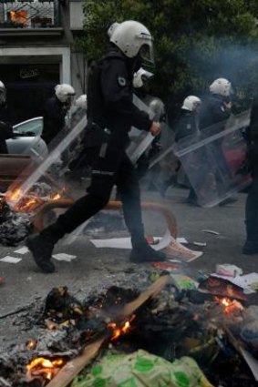 Police walk past burning debris in Istanbul's Cihangir district during the anniversary protests.