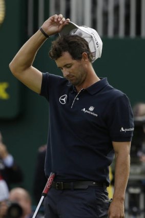 Adam Scott reacts after missing a putt on the 18th green.