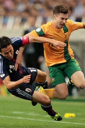 Tommy Oar clashes with Makoto Hasebe of Japan.