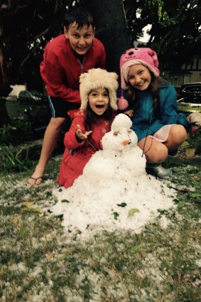 Rose Bay residents Xavier, India and Caitlin make the most of hail on Anzac Day.