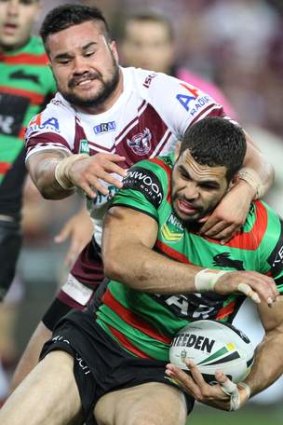 Greg Inglis attempts to duck under a tackle from Justin Horo.