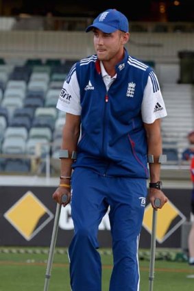 Stuart Broad walks across the outfield on crutches after play ended for the day.