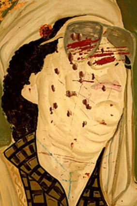 A vandalised portrait of Muammar Gaddafi.