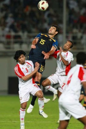 Mile Jedinak of Australia heads the ball over Abdulrahman Amer of the UAE.