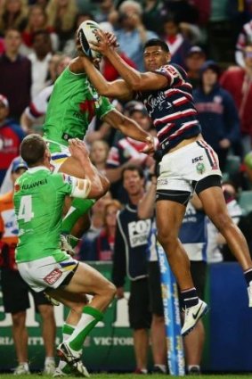 Taking flight: Daniel Tupou flies high to score against Canberra.