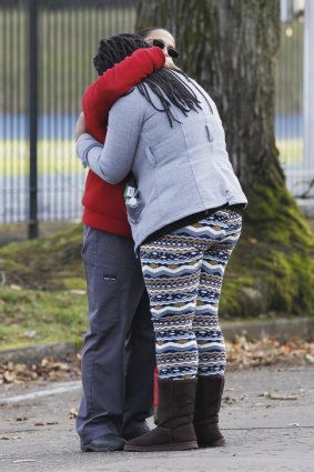 A student is reunited with a family member outside the Rosemary Anderson High School in Portland, Oregon, on December 12, 2014. 