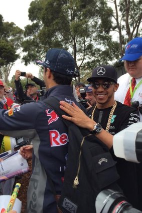 Lewis Hamilton pats Daniel Ricciardo on the back and quips, "Would you like something signed?"
