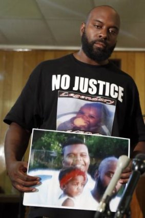 Michael Brown snr holds up a photo of himself with his son, Michael Brown.