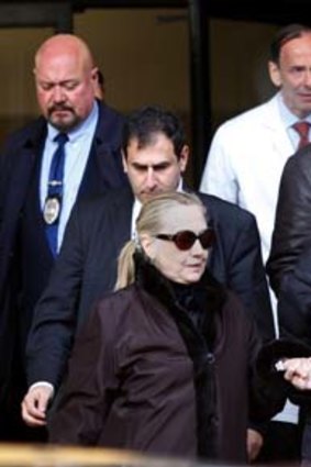 Back on deck ... Hillary Clinton, holding her daughter Chelsea's hand, leaves the New York hospital while a smiling Bill Clinton, top right, follows behind.